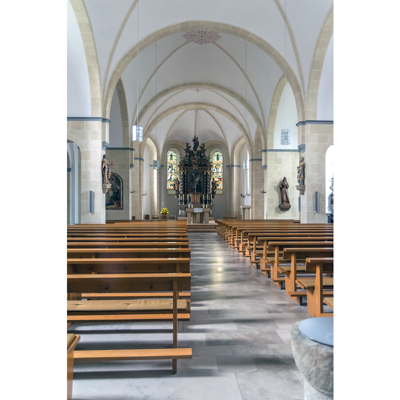 Source caption: "Katholische Kirche St. Johannes Enthauptung in Warburg-Ossendorf; Mittelschiff mit Blick auf Chor" -- with a partial view of the baptismal font in the bottom-right corner of the image, i.e., the west end of the centre aisle