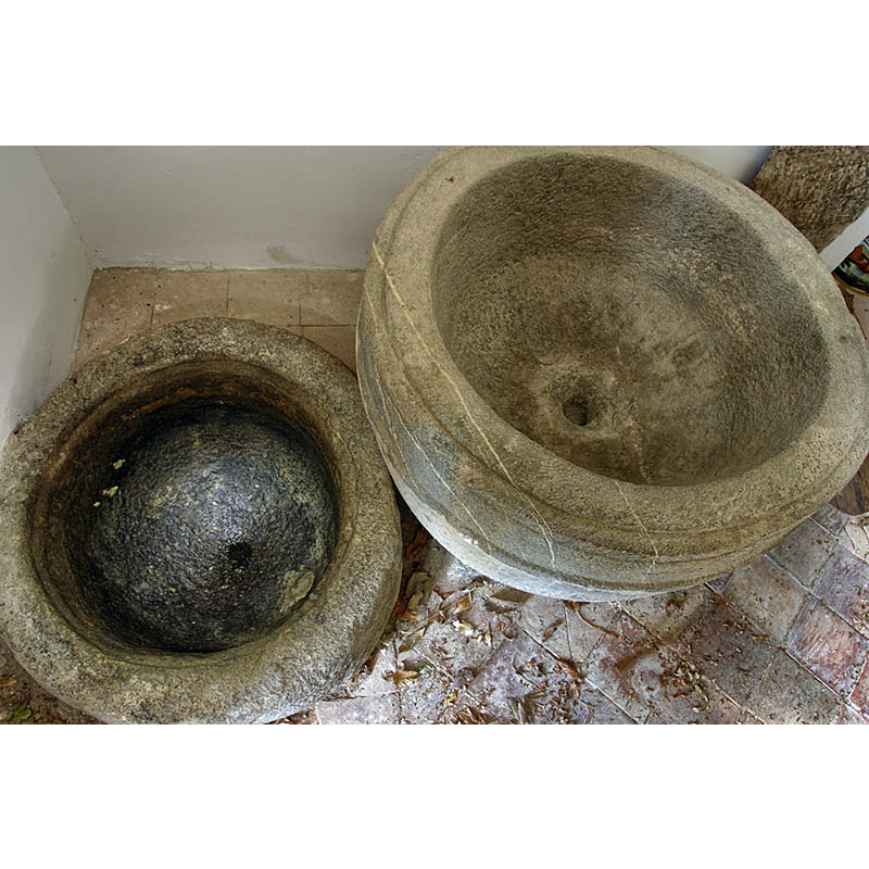 the baptismal font on the right; the oil tithe font on the left, with a cover; they are both unlined and both have centre drain holes