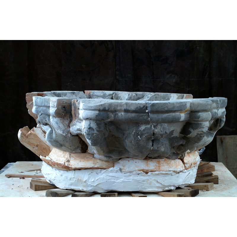 the fragments of the old limestone font arranged here during the reconstruction in Daniel Priese's workshop