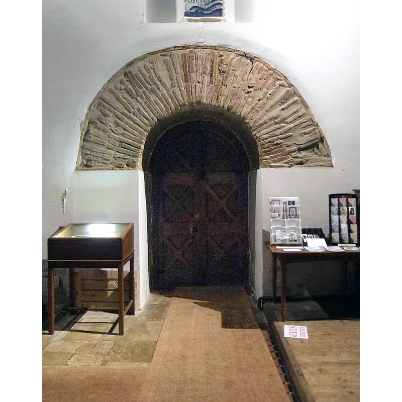 Source caption: "Anglo-Saxon arch at Brixworth. At the western end of the nave - so I presume that the door gives access to the narthex beneath the tower. 
The massiveness of the arch is fairly typical of Anglo-Saxon work, and so are the re-cycled Roman materials of which it was built - Anglo-Saxon builders in England often salvaged bricks and tiles from Roman sites."