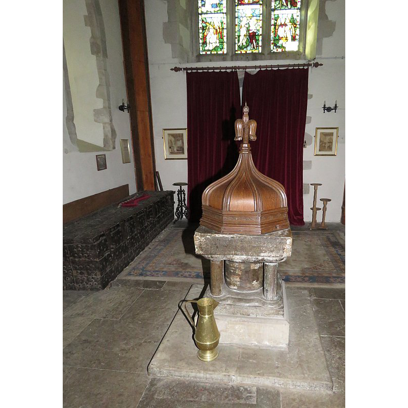 Source caption: "Font, square basin supported on a squat central plinth with four smaller pillars around, the base reset. Mid-13th Century and made of Purbeck stone."