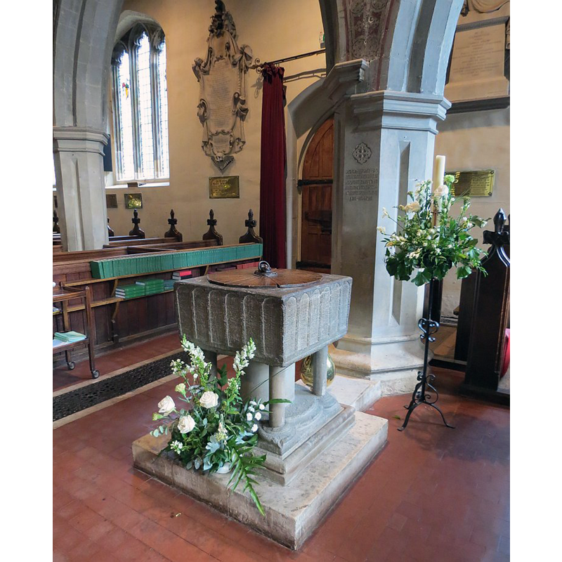 Source caption: "stone font with a square top, arcaded, on a central shaft with four outer columns – this would seem to date back as far as the earliest portions of the Church"