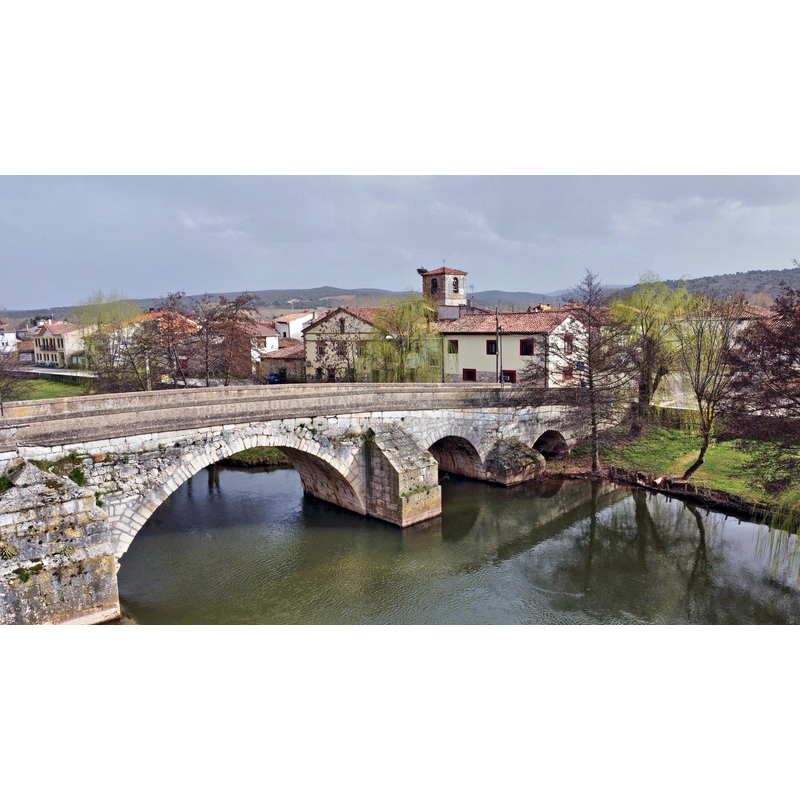 Source caption: "Vista aérea puente río Arlanza en Puentedura" -- the church tower with its crane and nest seen here in the centre of the image