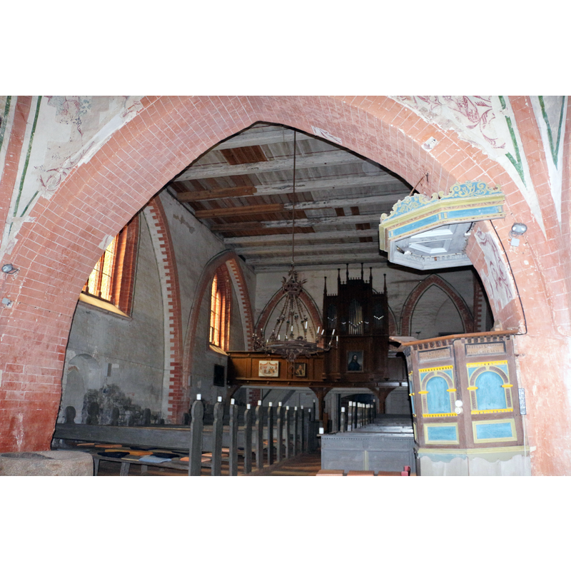 Source caption: "Blick nach Westen in der Kirche von Kirch Kogel mit Kanzel und Orgel" [NB: the stone object partially visible in the bottom-left corner of the image is the medieval stone baptismal font]