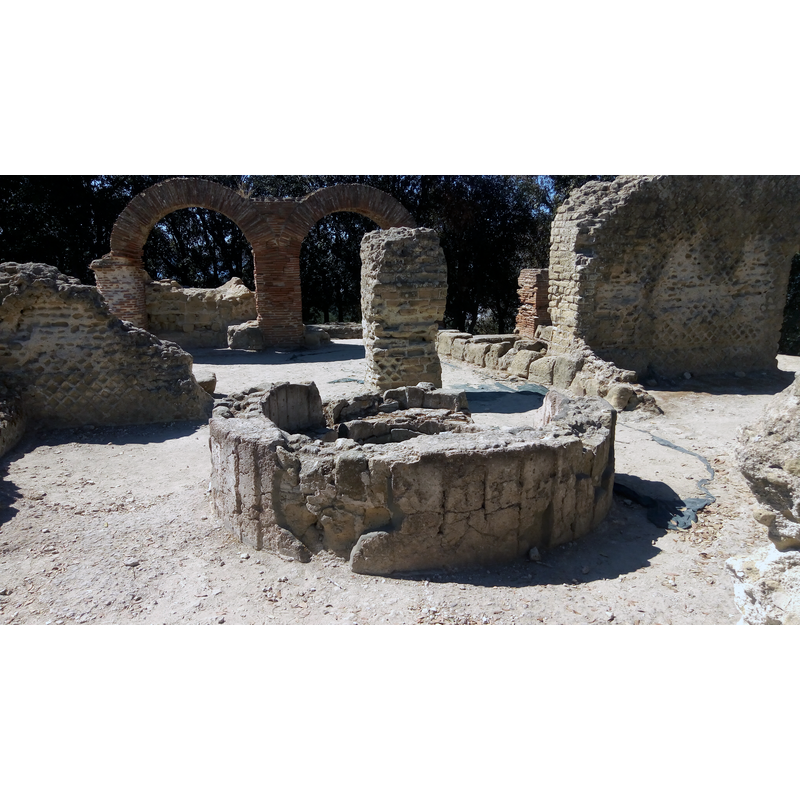 Source caption: "Scavi archeologici di Cuma" -- some of the polished stone lining on the exterior of the font remains around the outer sides