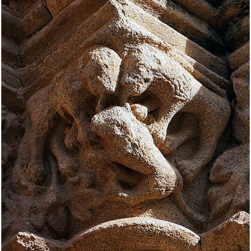 Source caption: "Dos leones simétricos que parecen lamer la cabeza de otro que se encuentra bajo ellos."