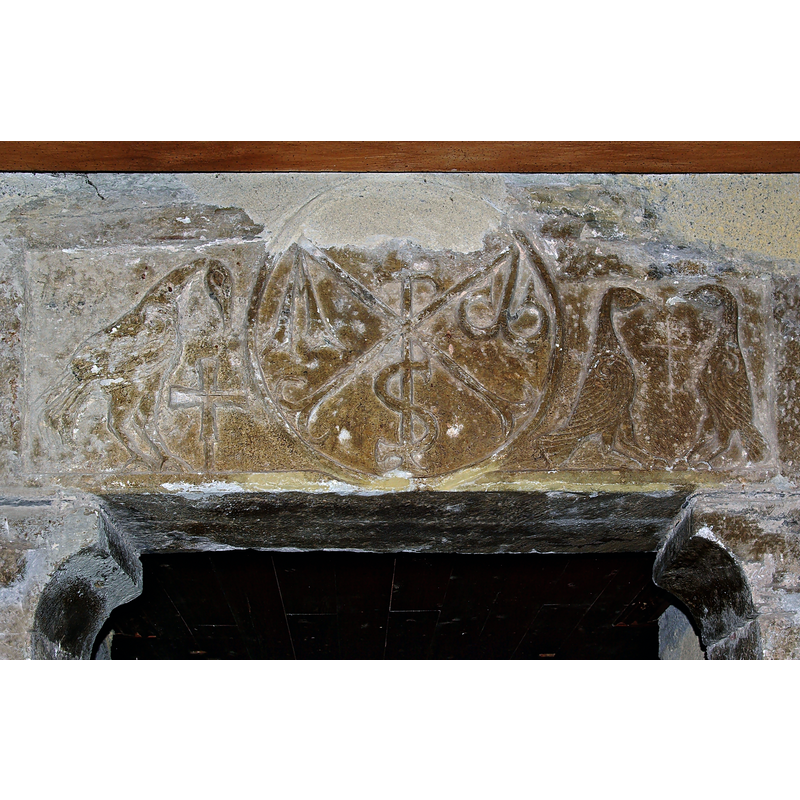 Source caption: "Chrisme (XIIe siècle ?) avec alpha et oméga, aigle et croix grecque à gauche, deux oiseaux à droite. Entrée de l'église de Sers, Hautes-Pyrénées, France."