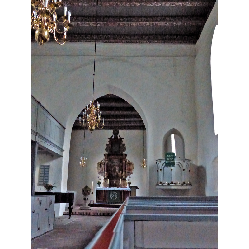 Source caption: "Triumphbogen der frühgotischen Backsteinkirche ion Eckwarden" -- showing the baptismal font and its cover just inside the chancel, left [north] side