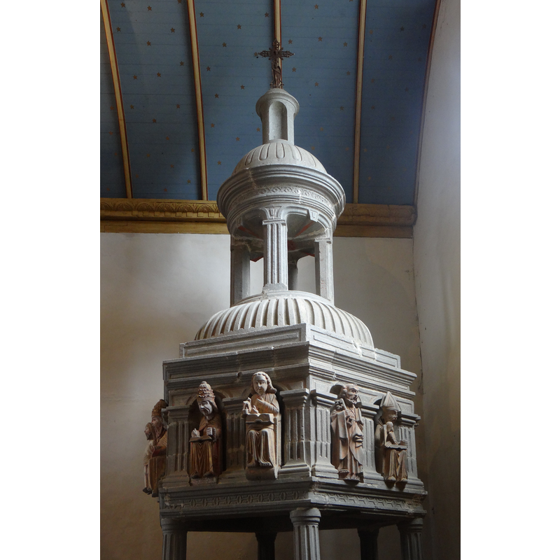 Source caption: "Église Notre-Dame de Bodilis, Finistère, France. Partie supérieure des fonts baptismaux du XVIème siècle en pierre, de forme hexagonale, orné de statues polychromes en kersantite attribuées à Roland Doré."