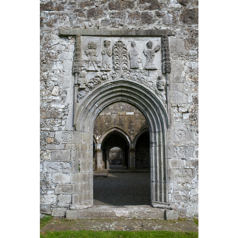 Source caption: "Clontuskert Priory, County Galway, Ireland. Ornate western doorway of the nave, depicting St Michael, weighing souls, St John, St Catherine, a bishop, and various other carvings including a pelican and a mermaid."