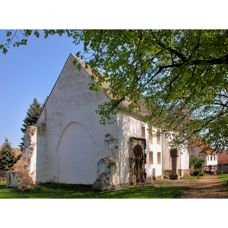 Source caption: "Hayna (Schkeuditz), Mittelstraße: Dorfkirche Hayna (GMP: 51.430650,12.310580). Ursprünglich romanisches Gotteshaus aus Feld- und Bruchsteinen. Auch das aufwändige Sandsteinportal auf der Südseite stammt aus der Romanik und erinnert an die Schmuckformen der Doppelkapelle von Landsberg und der Kirche von Naundorf bei Halle. Es stammte wohl mal von einer anderen, bedeutenderen Kirche, aber niemand weiß, von wo. Im 15. Jahrhundert wurde der spätgotischer Chor angefügt. Fast wäre die Kirche nach dem unerwarteten Einsturz des Kirchturmes im Jahre 1972 völlig abgerissen worden. Doch der Gemeindekirchenrat verweigerte damals die letzte Zustimmung und machte sich an den Wiederaufbau der Kirche. Sicht von Südwesten zum 1972 eingestürzten Turm."