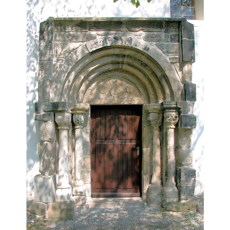 Source caption: "Dorfkirche Hayna (GMP: 51.430650,12.310580). Ursprünglich romanisches Gotteshaus aus Feld- und Bruchsteinen. Auch das aufwändige Sandsteinportal auf der Südseite stammt aus der Romanik und erinnert an die Schmuckformen der Doppelkapelle von Landsberg und der Kirche von Naundorf bei Halle. Es stammte wohl mal von einer anderen, bedeutenderen Kirche, aber niemand weiß, von wo."