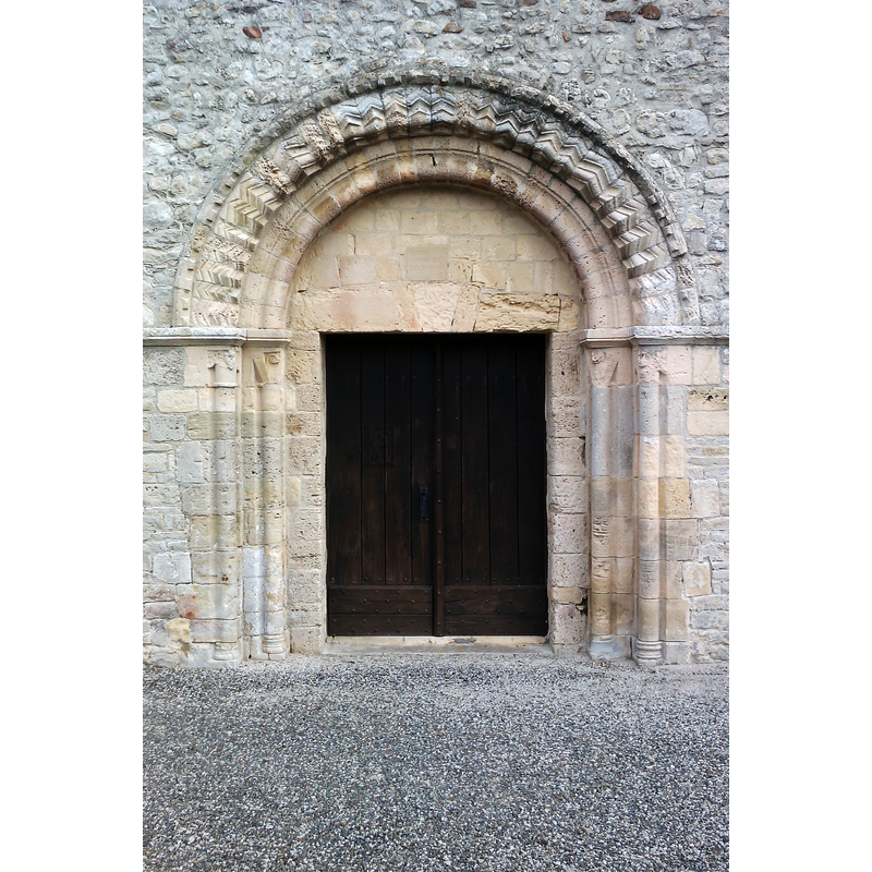 Source caption: "Église de Saint-Côme-du-Mont - Portail roman: portail avec archivolte formées de voussures ornées de chevrons et billettes reposant sur des piédroits de deux colonettes engagées à chapiteau sculpté"