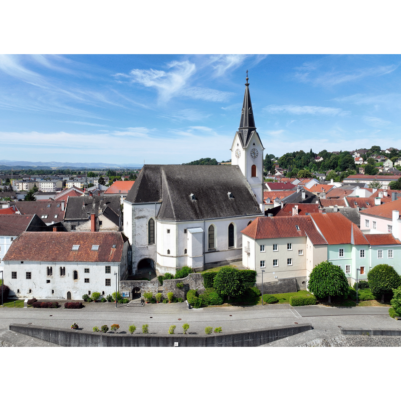Source caption: "Nordostansicht der Pfarrkirche hl. Laurentius in der niederösterreichischen Stadtgemeinde Ybbs an der Donau und links davon der „Passauer Kasten“. Im Bereich des Mittelschiffes gab es einen romanischen Vorgängerbau, der um 1200 urkundlich genannt wurde. Das spätgotische Staffel-Langhaus wurde 1466 eingewölbt. Der Turm stammt aus dem 13. Jahrhundert und wurde nach einem Brand im Jahr 1716 erhöht und fassadiert."