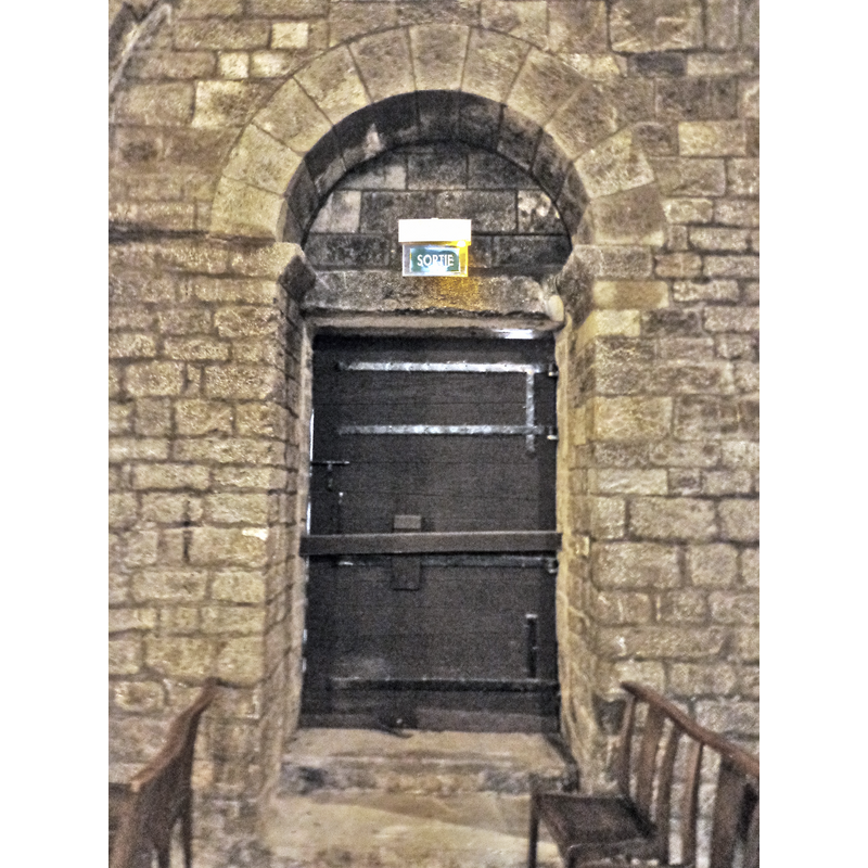 Source caption: "Frontignan (Hérault) - Église Saint-Paul - vue intérieure de la porte de l'église romane primitive. Remarquer le mode de fermeture reconstitué : une barre coulissante dans le mur roman."