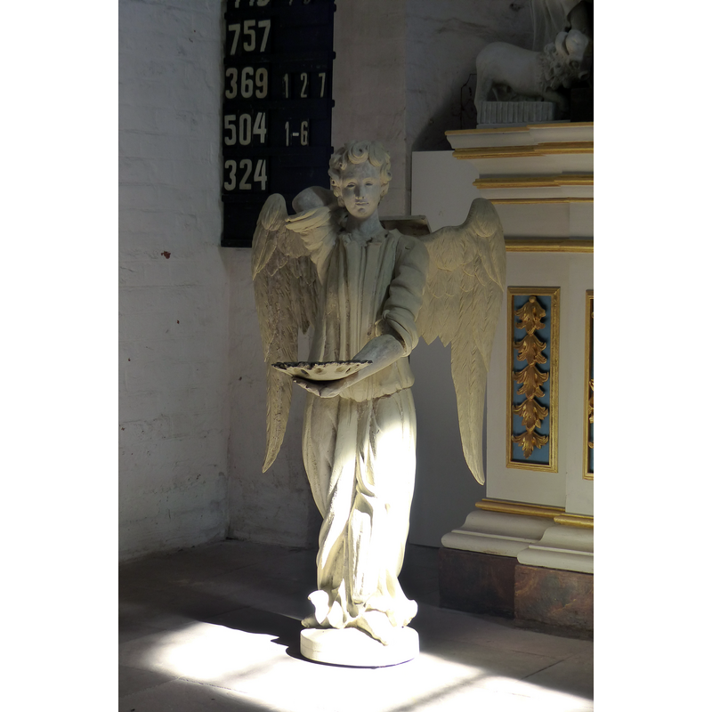 Source caption: "Auffallendes Interieur ist die anmutige Skulptur eines Taufengels im Chorbereich"