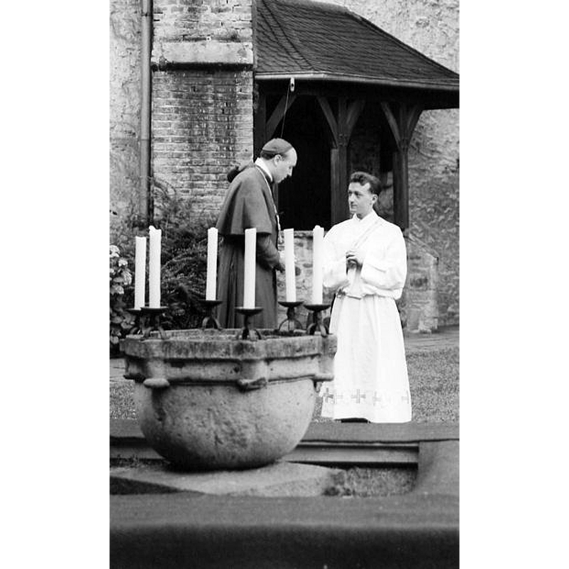 Source caption: "Das Theaterstück "Die Berufung"	 wurde am 19.08.1962 zum 40. Priesterjubiläum von Pastor Hans Wichert im Quadrum aufgeführt. In der Mitte der noch nicht restaurierte Taufstein, der jetzt unter dem Turm in der Kirche steht." [NB: the medieval basin from Friesdorf seen here in Oberpleis, before its restoration and installation inside the church]
