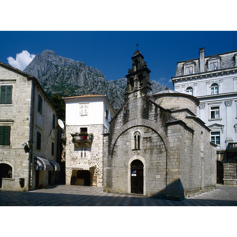 Source caption: "Auf dem Trg Bratstva i jedinstva, »Platz der Brüderlichkeit und Einheit«; er heißt inzwischen Trg Svetog Luke, die Lukaskirche ist die örtliche (montenegrinisch)-orthodoxe Kirche."