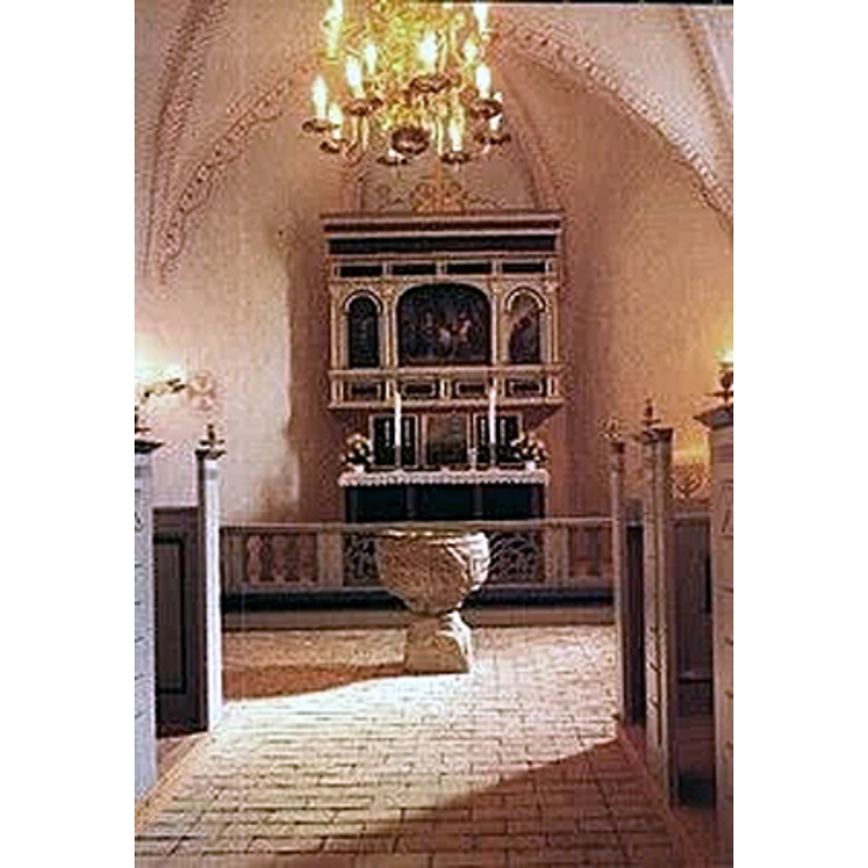 Source caption: "Døbefonten fra omkring år 1200 er romansk, udhugget med løvefigurer. Den har indtil 1883 været bemalet med murfarve. "