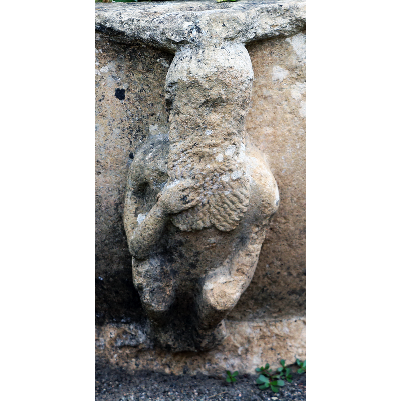showing one of the crouching or sitting figures; this one raises his right hand to his large broad beard