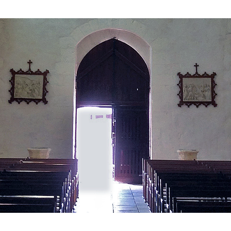 showing the tops of two holy-water stoups [modern?] at left and right of the west entranceway