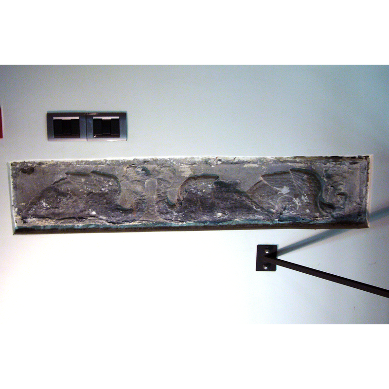 the fragment of the medieval font as displayed in the sacristy