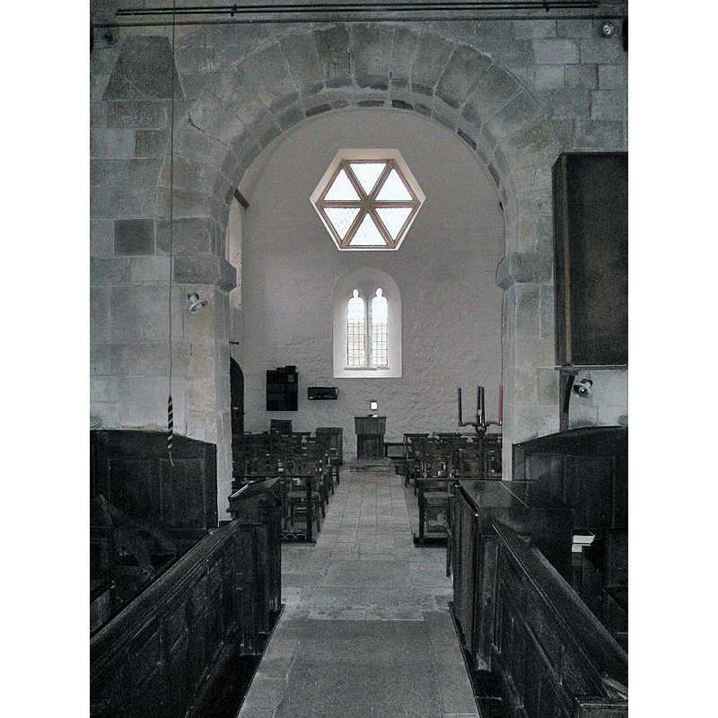 Source caption: "Interior of Elsted church looking west. The small square window beneath the big windows is probably a leper's window." -- showing the font at the far [west] end