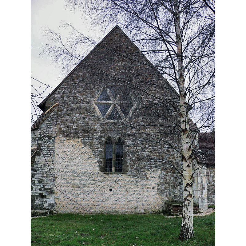 Source caption: "The western elevation of Elsted church. The leper's window is below the big windows" -- showing the great contrast between the Anglo-Saxon(?) 'opus spicatum' on the bottom left and the rest of the stone work on the west facade