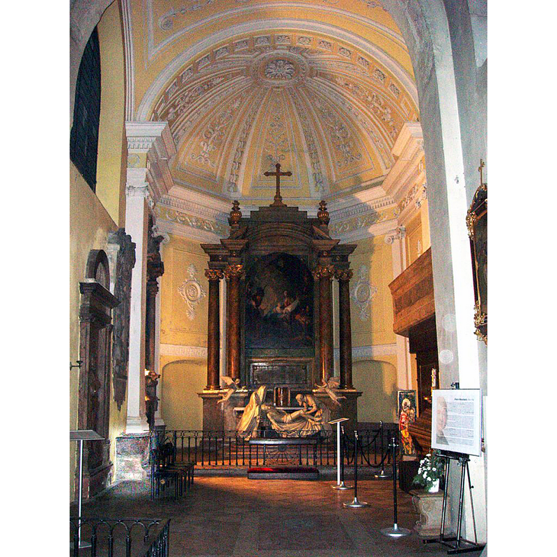 Source caption: "Wien, Michaelerkirche, Nordchor („Krippen-Kapelle“), Altar mit Altarblatt von Maulbertsch, davor Gips-Skulpturengruppe von F. Käßmann: Grablegung Christi, 1819." -- the font, partialle mounted against the left wall, is highlighted in the bottom-left corner of the image