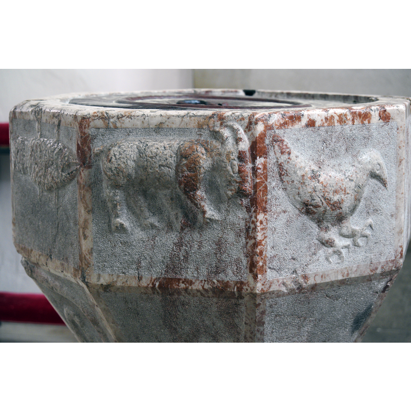 Source caption: "Katholische Pfarrkirche St. Benedikt in Altmünster im Bundesland Oberösterreich (Österreich), romanisches Taufbecken" -- showing [L-->R]: fish-goat-dove