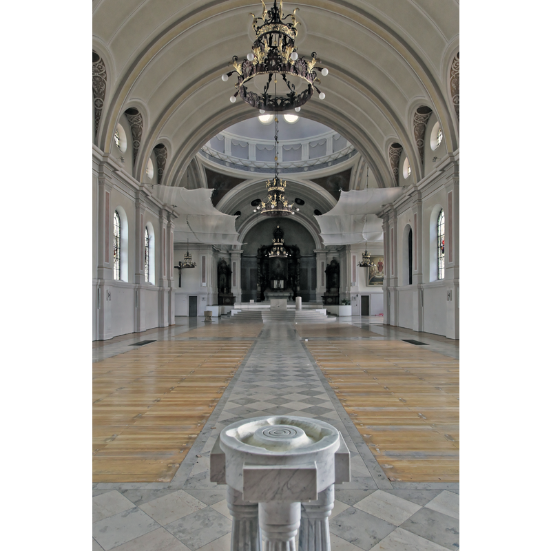 Source caption: "Während der Renovierung leerer Kircheninnenraum von St. Martinus, Kirchplatz / Martinusplatz in Haren (Ems)" -- the modern holy-water stoup in the foreground and the medieval font in the far back, northwest corner of the nave