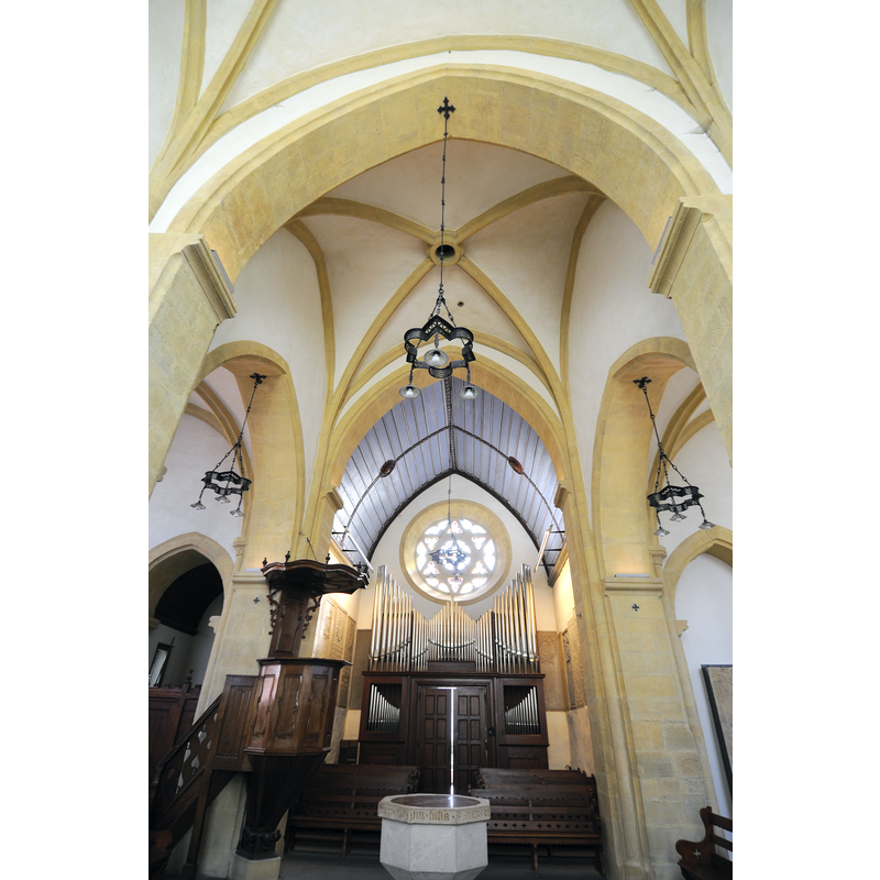Source caption: "Coeur de la collégiale de Valangin" -- showing the baptismal font in the foreground