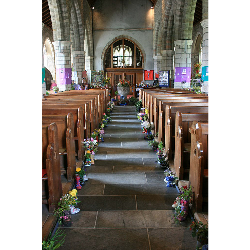 Source caption: "Flower festival, St Petrocs Church, South Brent" -- showing the old baptismal font partly covered in floral arrangements
