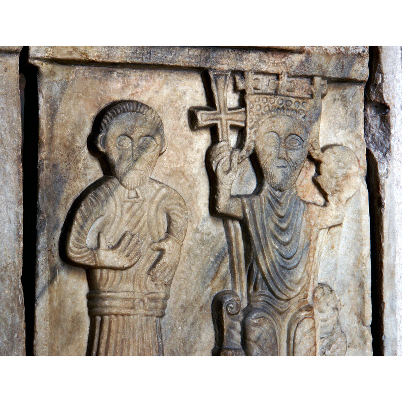 the elegantly attired bearded figure on the left next to the king, has lost wahtever he was carrying in his arms; notice the three crosses on the king's crown [cf. FontNotes]