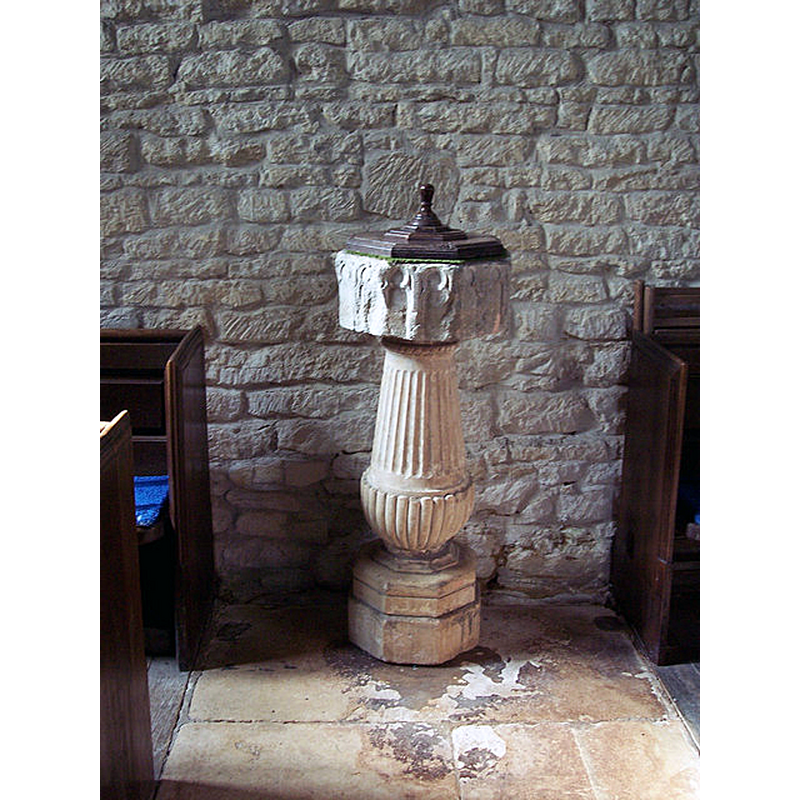 Source caption: "Church of St Mary Magdalene, Fifehead Magdalen - Old Font.  This old font stands beneath the west window. The Purbeck marble bowl is fifteenth century and it stands on an eighteenth century fluted pedestal. Church records show that the wooden cover for the font was made by the parish clerk in 1774."