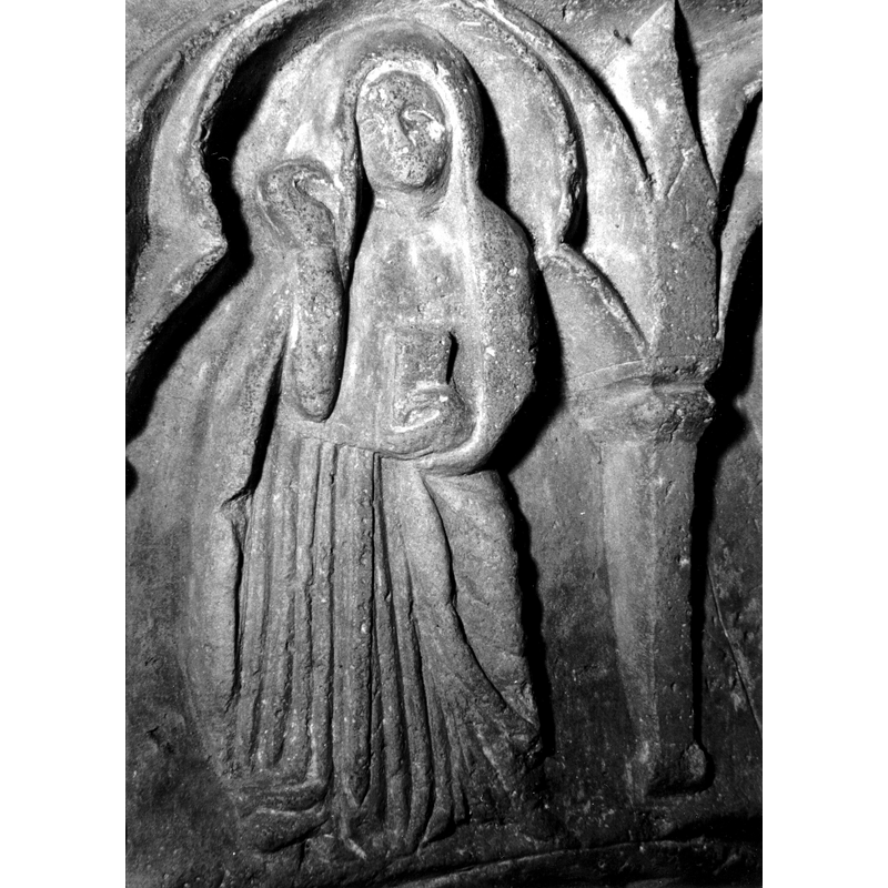 Source caption: "Detalle de una de las figuras de la parte superior de la pila bautismal gótica; se representa la escena de la Anunciación. Es un detalle de la figura de la Virgen, que levanta el brazo en actitud de turbación [...] pila bautismal de la iglesia de la Natividad de Hueto Arriba"