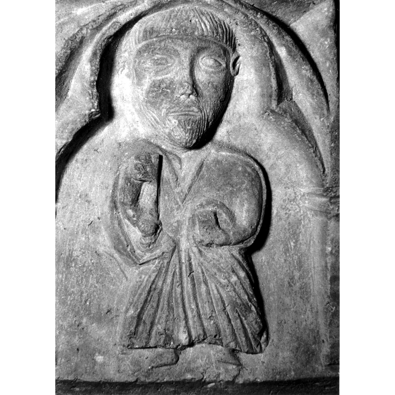 Source caption: "Detalle de una de las figuras de la parte superior de la pila bautismal gótica; se representa una figura de hombre, posiblemente San Pedro, al presentar una llave en su mano [...] pila bautismal de la iglesia de la Natividad de Hueto Arriba"