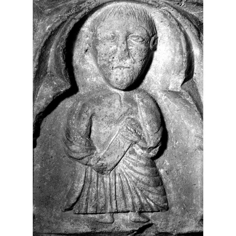 Source caption: "Detalle de una de las figuras de la parte superior de la pila bautismal gótica; se representa una figura de hombre, un apóstol, profeta o fraile franciscano con una cartela en las manos, entre arquerías polilobuladas [...] pila bautismal de la iglesia de la Natividad de Hueto Arriba"