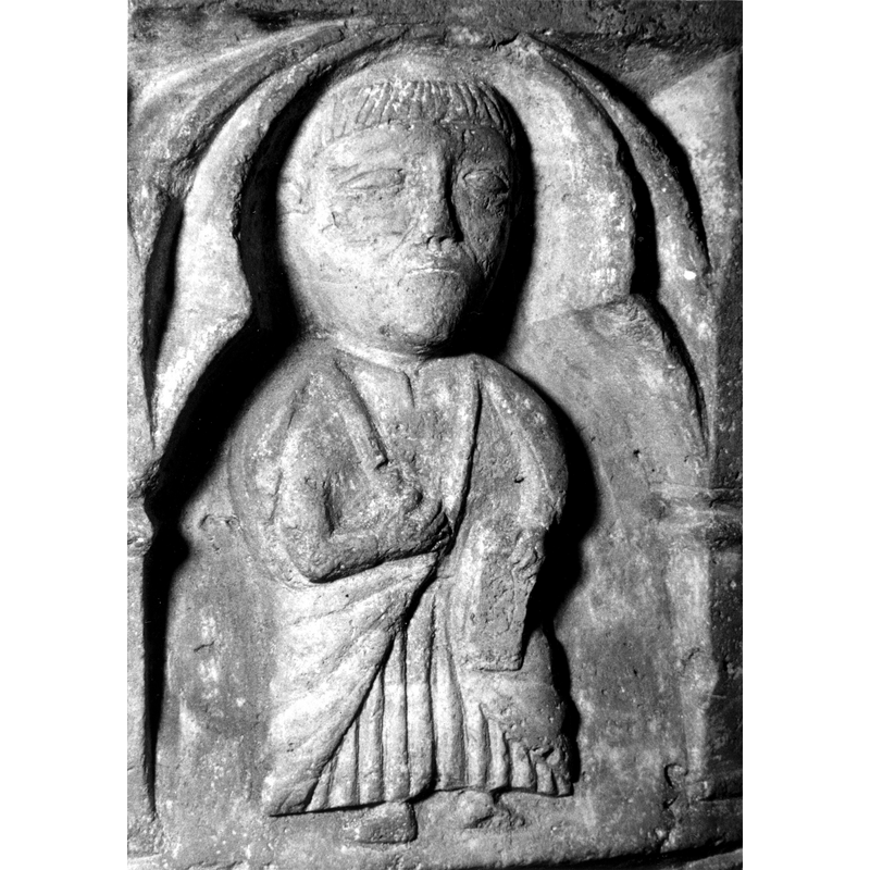 Source caption: "Detalle de una de las figuras de la parte superior de la pila bautismal gótica; se representa una figura de hombre, posiblemente un apóstol, entre arquerías polilobuladas [...] pila bautismal de la iglesia de la Natividad de Hueto Arriba"