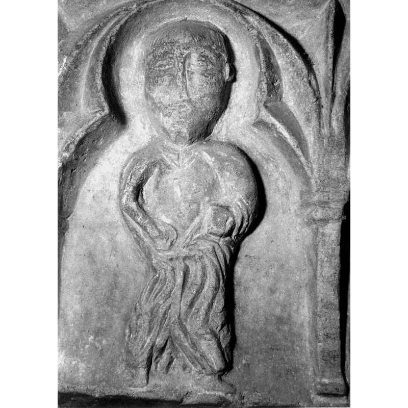 Source caption: "Detalle de una de las figuras de la parte superior de la pila bautismal gótica; se representa una figura de hombre, un apóstol, profeta o fraile franciscano, entre arquerías polilobuladas [...] pila bautismal de la iglesia de la Natividad de Hueto Arriba"
