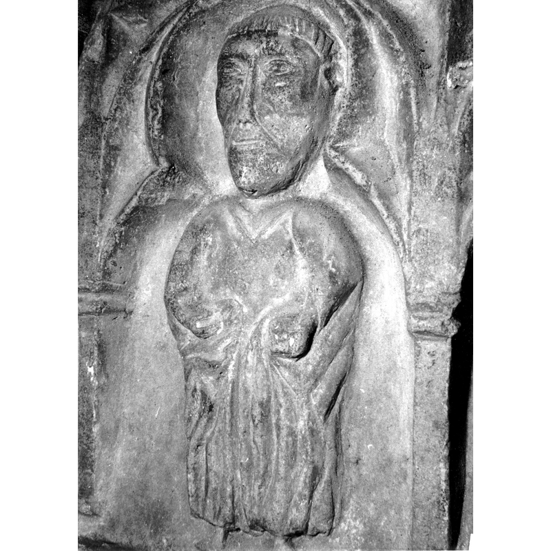 Source caption: "Detalle de una de las figuras de la parte superior de la pila bautismal gótica; se representa una figura de hombre, un apóstol, profeta o fraile franciscano, entre arquerías polilobuladas [...] pila bautismal de la iglesia de la Natividad de Hueto Arriba"