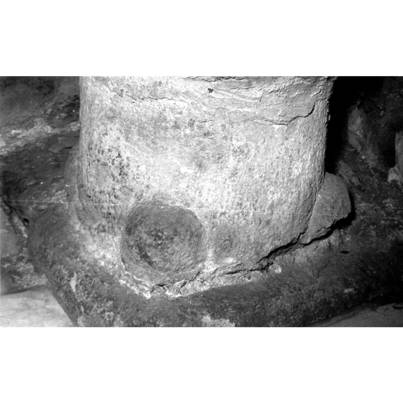 Source caption: "Detalle de la basa de la pila bautismal, presenta cuatro mascarones en los extremos [...] pila bautismal de la iglesia de Santa Coloma de Paúl" -- one is missing, another appears to be a plain ball; the third is broken