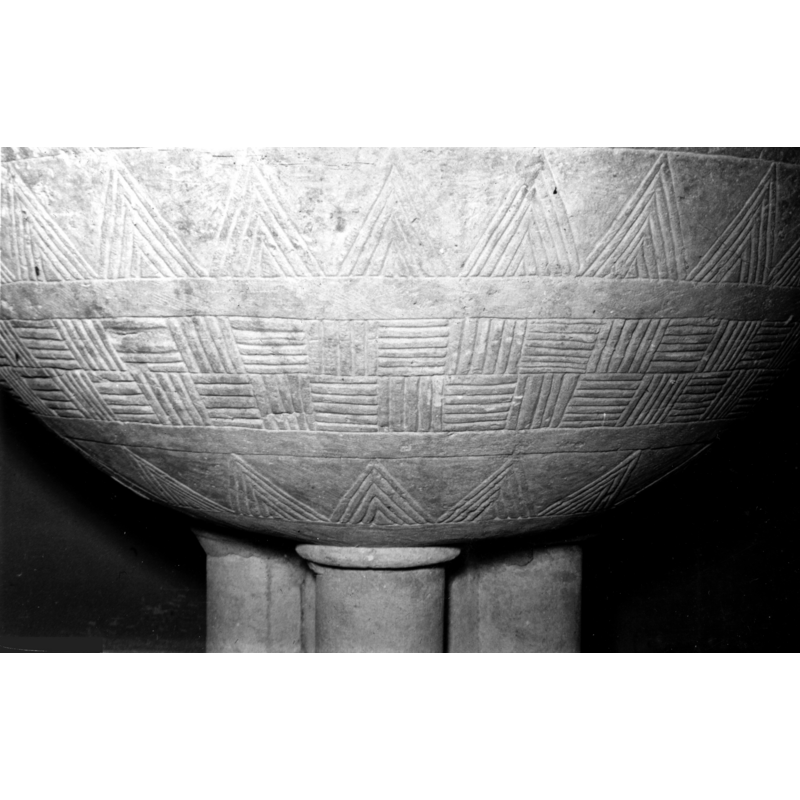 Source caption: "Detalle de la copa de la pila bautismal románica; está completamente cubierta de decoración incisa. Se ornamenta con bandas de encestado inciso y alternando con ellas, otras de dentellones muy agudos [...] pila bautismal de la iglesia de San Pedro de Zuazo de Cuartango"