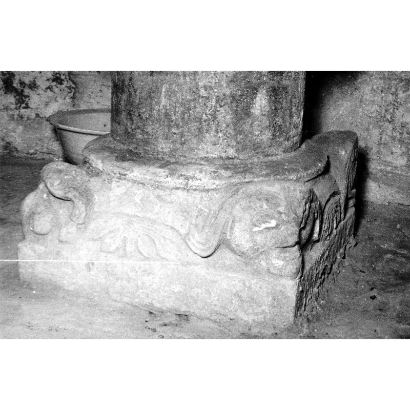 Source caption: "Vista frontal de la basa de la pila bautismal; está decorada con cuatro mascarones y elementos vegetales geometrizados [...] pila bautismal de la iglesia de San Martín de Arlucea"