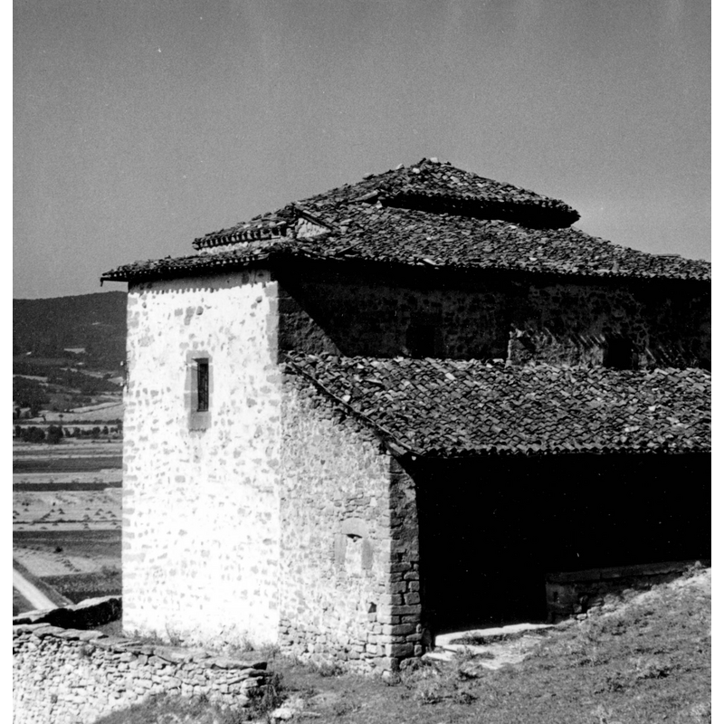 Source caption: "Iglesia de San Miguel de Hereña [...] Vista frontal de la iglesia de fábrica de mampostería; presenta un amplio pórtico de tipo rural y torre cuadrada en la pared norte que apenas sobresale de las naves del templo"