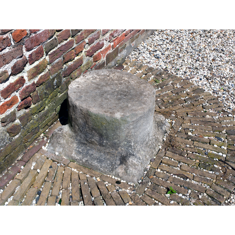 the base of the medieval font here, according to one source [cf. FontNotes]: Outside the church is the base and column of the font, and these were used as "roepsteen" or "pierre de criée" for public announcements.