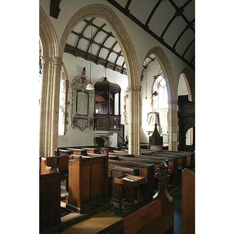 Source caption: "Selworthy: church interior. Inside All Saints. Looking towards the south aisle erected in 1538. Members of the Acland family, lords of the manor, had their own private pews in a room above the south porch, described by Nikolaus Pevsner as ‘a delicious Gothic pavilion’. It can be seen here, to the right of an Acland wall monument" -- showing the font and cover at the far end