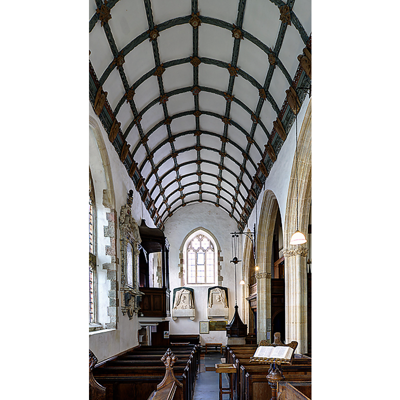 Source caption: "All Saints church, Selworthy - south aisle roof. The waggon-roof of the south aisle is one of the finest in the county, having richly decorated wall-plates with angels holding shields, braces and purlins. The two Chantrey monuments of the Dyke Aclands are on the end wall." -- showing the font, cover and pulley system at the far end, right side