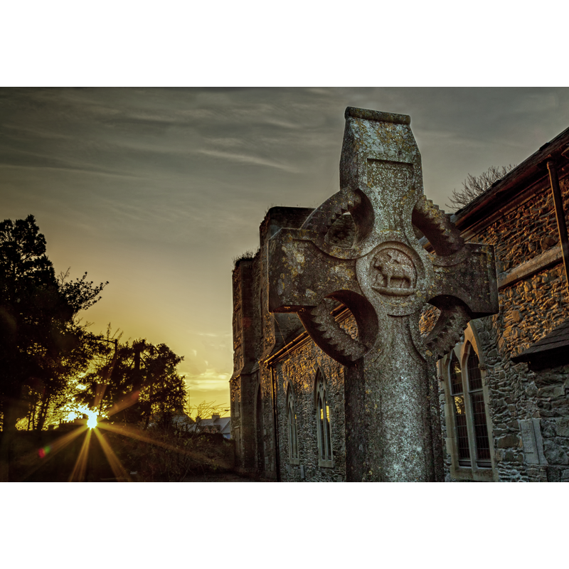 Source caption: "Hand cut Celtic Cross at St. David's church Naas. Captured at sunset on Remembrance Sunday. The carving of the stone is replicated in the window carvings and communion table in the church."