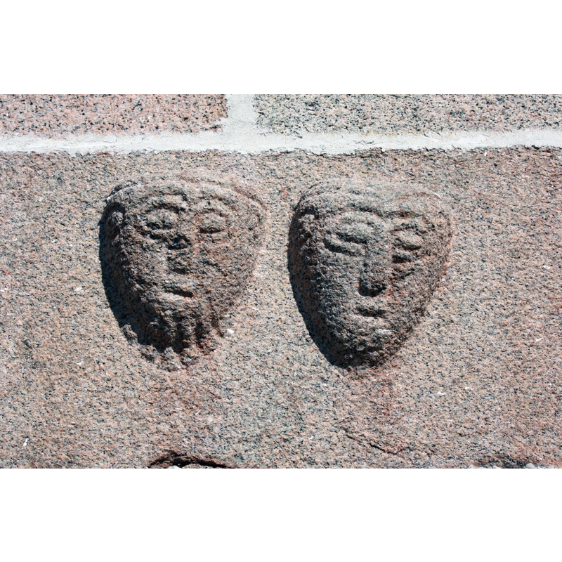Source caption: "Stone carving of mens faces made around 1200 from Ålum Church, Mid-Jutland, Denmark."